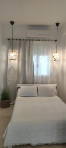 ニキティにあるNeaktion Apartmentsのベッドルーム1室(白い大型ベッド1台、照明2つ付)