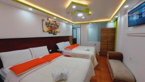 Cette chambre comprend 2 lits et une télévision. dans l'établissement Hostal La Siesta, à Baños