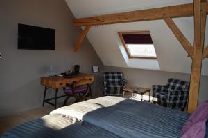 a bedroom with a bed and a desk with chairs at Hoeve Lavigne in Wellen