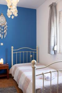 a bedroom with a bed with a blue wall at Rural Residence in Skouloúfia