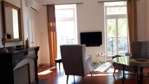 een woonkamer met een open haard en een televisie bij Appartement avec balcon, bord du canal, Wifi. in Narbonne