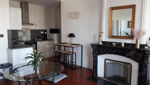 - un salon avec une cheminée, une table et un miroir dans l'établissement Appartement avec balcon, bord du canal, Wifi., à Narbonne