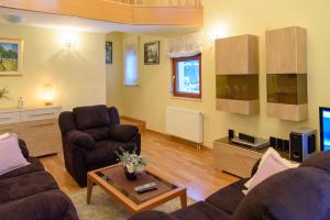 a living room with two couches and a tv at Villa Bjelolasica in Jasenak