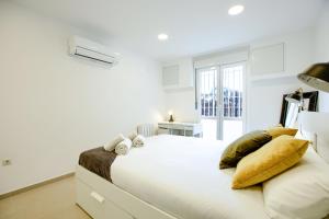 1 dormitorio blanco con 1 cama grande con almohadas de oro en Charming Madrid La Elipa - 3 dormitorios, en Madrid