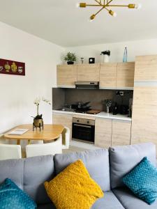 Maisonnette indépendante au calme في فيتيل: غرفة معيشة مع أريكة زرقاء ومطبخ