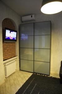 a large glass cabinet in a room with a television at Modern Apartments in Petergof