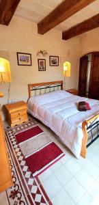 um quarto com uma cama grande e uma mesa em Ta Majsi farmhouse with indoor heated pool em San Lawrenz