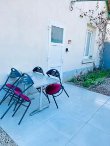 een tafel en twee stoelen naast een gebouw bij Maisonnette indépendante au calme in Vittel