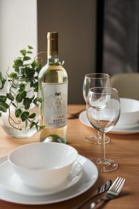 a bottle of wine sitting on a table with plates and glasses at THE HOUSE near Lake & Old Town in Olsztyn +45 photos