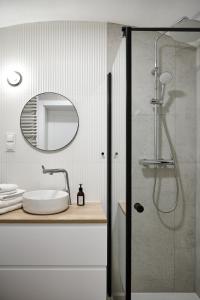 a bathroom with a shower with a sink and a mirror at THE HOUSE near Lake & Old Town in Olsztyn