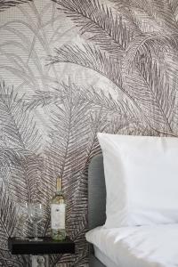 a bedroom with a bed and a wall with a palm leaf wallpaper at THE HOUSE near Lake & Old Town in Olsztyn