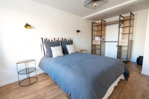 ル・トレポールにあるL'air Du Temps - appartement cosy au Tréportの青い毛布が掛けられた大きなベッドのある寝室