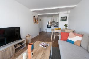 ル・トレポールにあるL'air Du Temps - appartement cosy au Tréportのソファと薄型テレビのあるリビングルーム