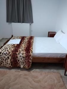 Un dormitorio con una cama con una manta de leopardo. en Kimi apartments 1, en Kími