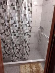 La salle de bains est pourvue d'une douche avec rideau de douche. dans l'établissement Kimi apartments 1, à Toluca