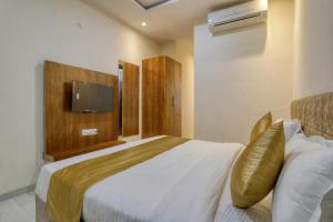 1 dormitorio con 1 cama y TV en la pared en SoonStay Konark, en Indore