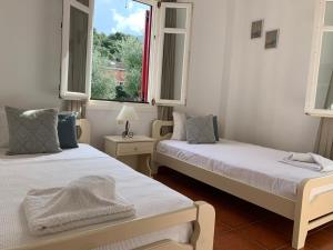 duas camas num quarto com duas janelas em Pandora Villa em Vathi