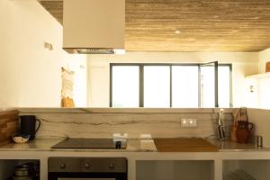 una cucina con piano di lavoro e finestra di Vida na Vila a Vila Nova de Milfontes