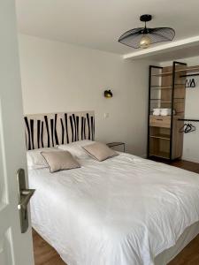 ル・トレポールにあるL'air Du Temps - appartement cosy au Tréportの大きな白いベッドと枕が2つある寝室