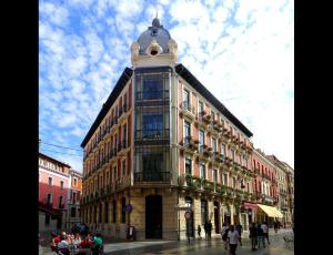 un edificio con una torre dell'orologio sopra di Leon Hostel a León