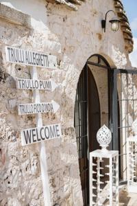 a street sign in front of a stone building at TRULLI ALLEGRETTI in Noci