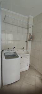 Baño pequeño con bañera y lavamanos en Apartamento Balneário Camboriu, en Balneário Camboriú