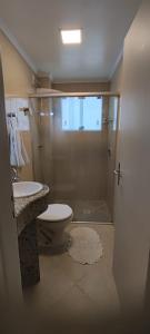 a bathroom with a shower and a toilet and a sink at Apartamento Balneário Camboriu in Balneário Camboriú