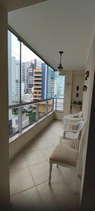 a balcony with a chair and views of a city at Apartamento Balneário Camboriu in Balneário Camboriú