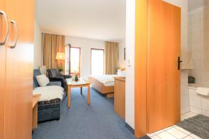 um quarto de hotel com uma cama e uma casa de banho em Ferienzimmeranlage Deutsches Haus Deutsches Haus App 18 em Wustrow
