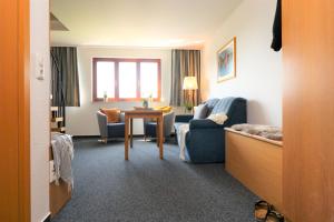 a hotel room with a table and a living room at Ferienzimmeranlage Deutsches Haus Deutsches Haus App 33 in Wustrow