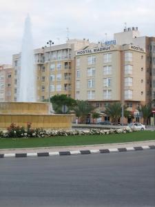 un edificio con una fuente frente a un edificio en Hostal Madruga, en Elche