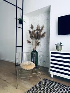 a living room with a vase with a plant in it at Rost Apartments in Bielsko-Biała