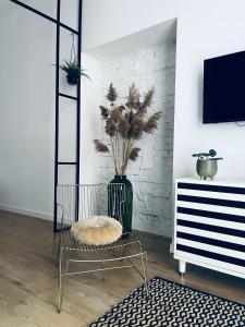una sala de estar con un jarrón con una planta en Rost Apartments, en Bielsko-Biala