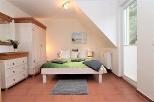 um quarto com uma cama com um cobertor verde em "Strandkoje" Strandkoje, App 07 em Neuhaus