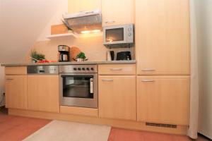 uma cozinha com um fogão e um micro-ondas em "Strandkoje" Strandkoje, App 07 em Neuhaus