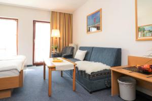 a hotel room with a couch and a bed at Ferienzimmeranlage Deutsches Haus Deutsches Haus App 29 in Wustrow