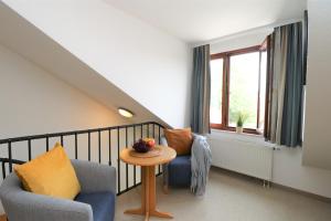 ein Wohnzimmer mit 2 Stühlen, einem Tisch und einem Fenster in der Unterkunft Ferienzimmeranlage Deutsches Haus Deutsches Haus App 35 in Wustrow