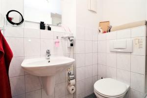 Baño blanco con lavabo y aseo en Ferienzimmeranlage Deutsches Haus Deutsches Haus App 35 en Wustrow
