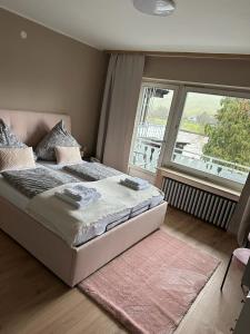 a bedroom with a large bed with a large window at Hotel Gonzlay in Traben-Trarbach