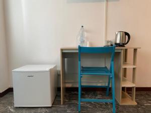 a blue chair sitting at a desk with a bottle of water at Mestre Residence in Mestre