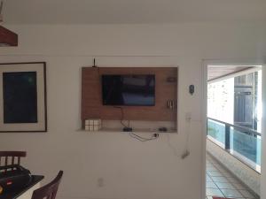 a flat screen tv on a wall in a living room at Apartamento Farol Barra Flat in Salvador