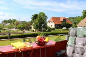 una mesa con un bol de fruta en el balcón en Ferienzimmeranlage Deutsches Haus Deutsches Haus App 22, en Wustrow