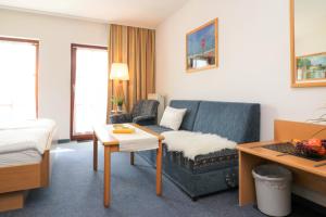 ein Hotelzimmer mit einem Sofa und einem Bett in der Unterkunft Ferienzimmeranlage Deutsches Haus Deutsches Haus App 25 in Wustrow