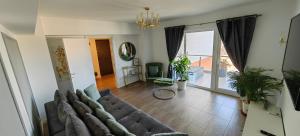 uma sala de estar com um sofá e uma grande janela em Luxury apartment private parking self check-in54 em Craiova
