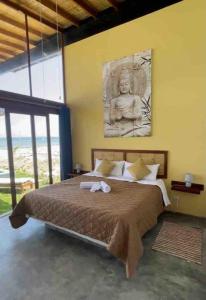 1 dormitorio con 1 cama grande y una estatua en la pared en Casa Aloha Punta Sal, en La Bocana