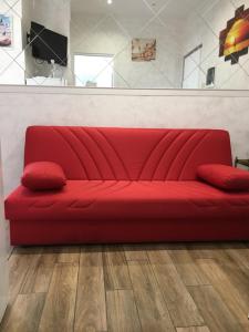 a red couch in a room with a wooden floor at IN CENTRO A RAPALLO in Rapallo