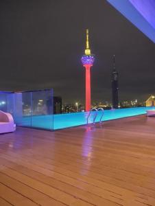 a rooftop with a view of the space needle at night at Pool View Platinum KLCC in Kuala Lumpur