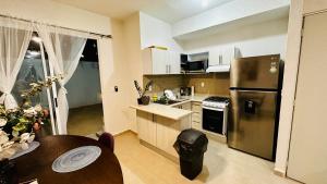 kuchnia ze stalową lodówką i stołem w obiekcie Franks House "Shared House" with Pool w mieście Cancún +3 zdjęcia