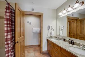 baño con 2 lavabos y espejo grande en The Springs Condominiums by Keystone Resort en Keystone