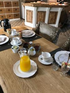 una mesa de madera cubierta con platos y tazas de zumo de naranja en Hoeve Lavigne, en Wellen